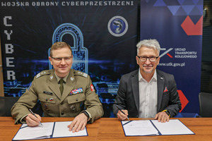 Dwóch mężczyzn od lewej gen. dyw. Karol Molenda, Dowódca Komponentu Wojsk Obrony Cyberprzestrzeni, dr inż. Ignacy Góra, Prezes UTK. Mężczyźni siedzą przy stole, podpisują porozumienie o współpracy.