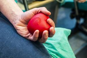 Ręka trzymająca gumową piłkę w kształcie serca podczas oddawania krwi