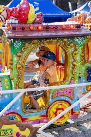 Chłopczyk i dziewczynka siedzący w małej kolorowej lokomotywie. Jednej z atrakcji przygotowanej przez Kolejowe ABC
