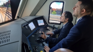 Prezes Zarządu Fundacji ProKolej, dr Jakub Majewski podczas prowadzenia pociągu Prezes siedzi kabinie symulatora. Na ekranie wyświetlana symulacja trasy podczas jazdy pociągiem